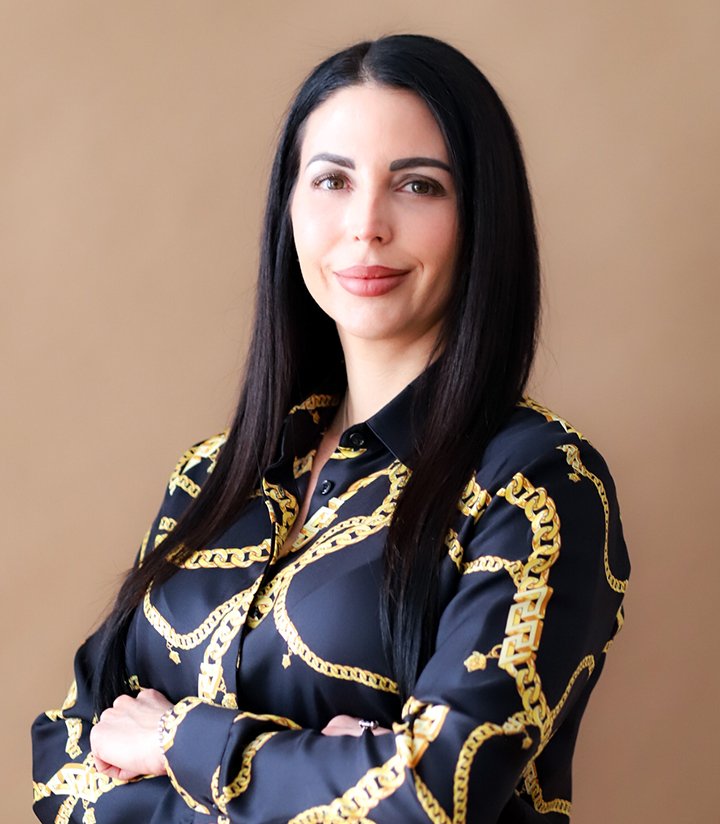Dr. Cassie Smith, M.D., leading endocrinologist at Modern Endocrine, wearing a black shirt with gold chain patterns, smiling confidently against a neutral background.